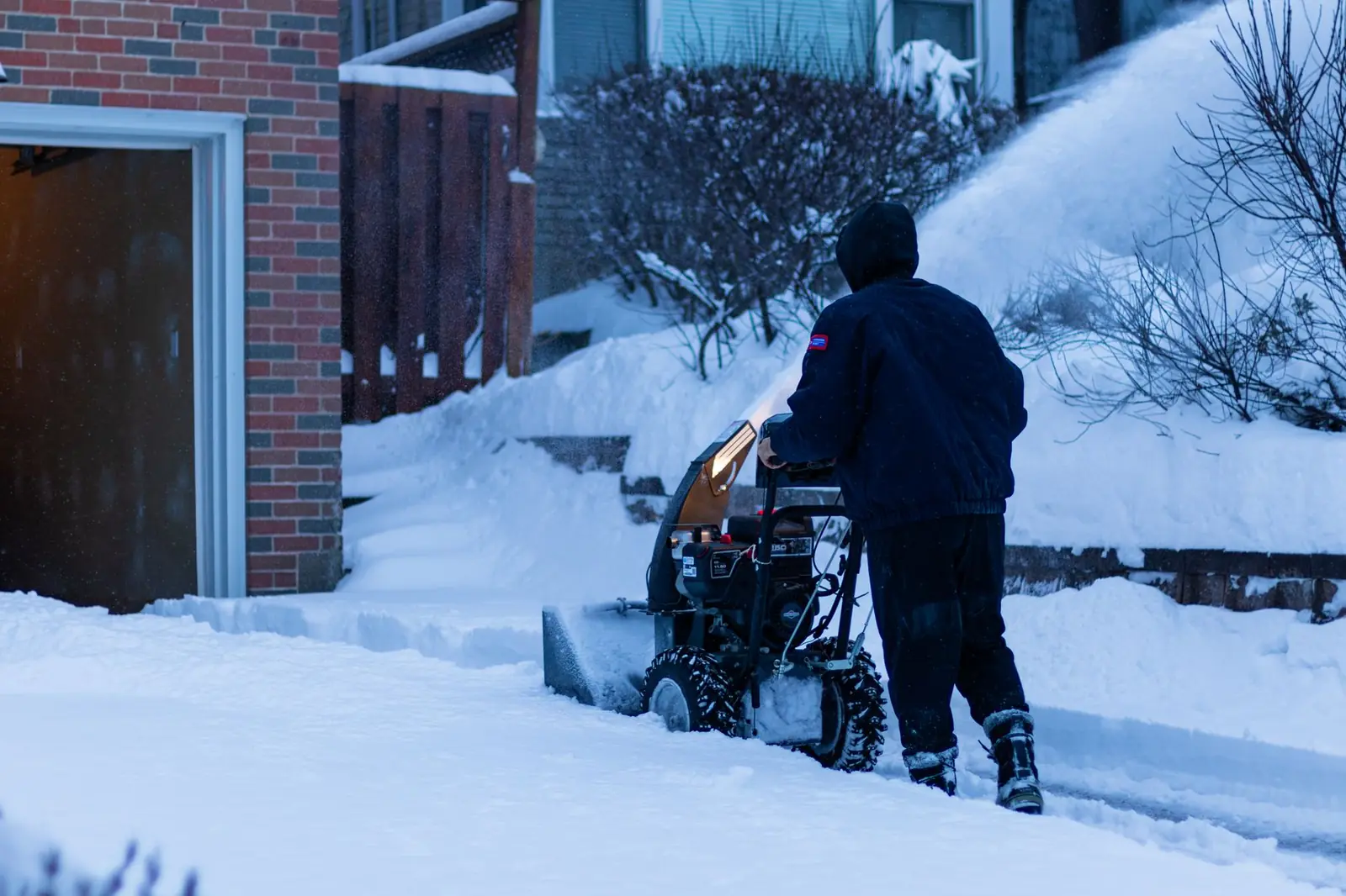 Clearing deep snow from a residential driveway with a snow blower